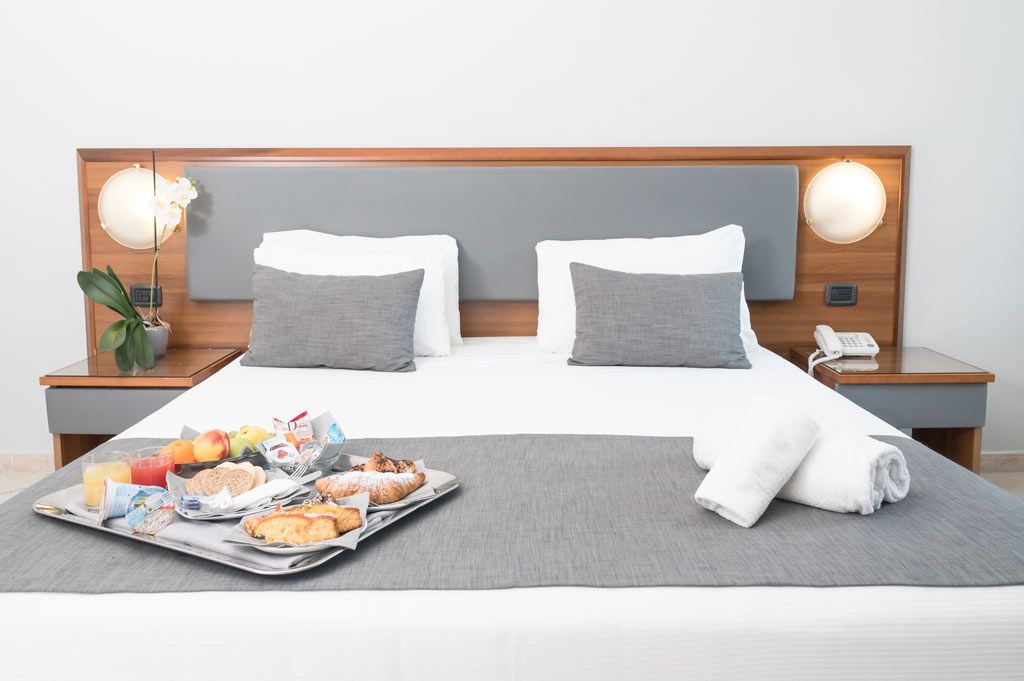 Superior room at Blu Hotel with double bed and breakfast tray