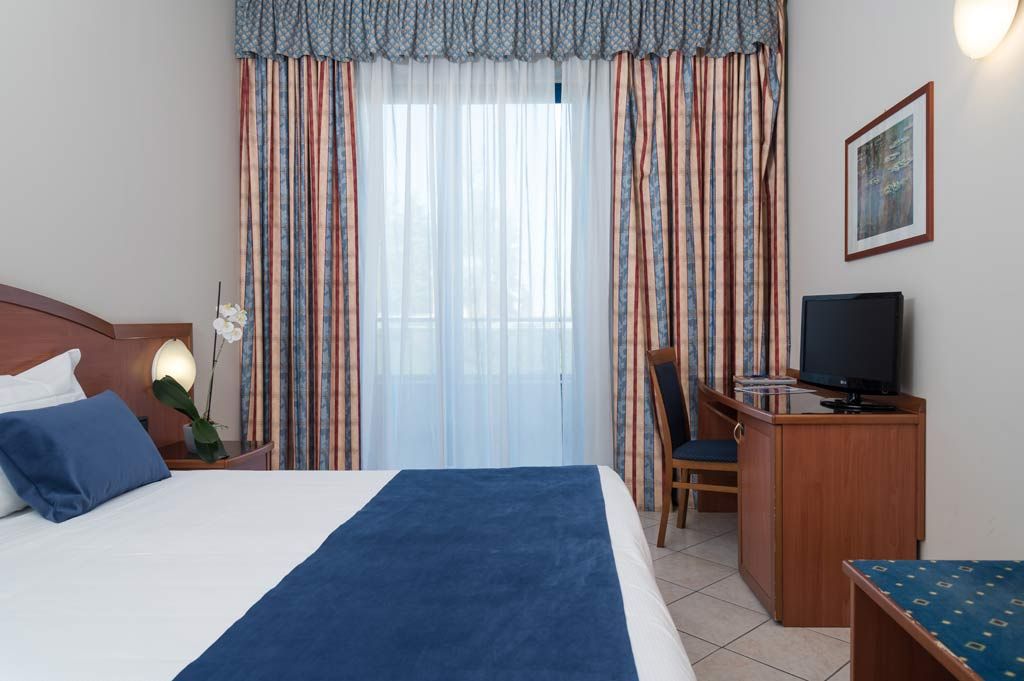Standard room at Blu Hotel with double bed, desk and window