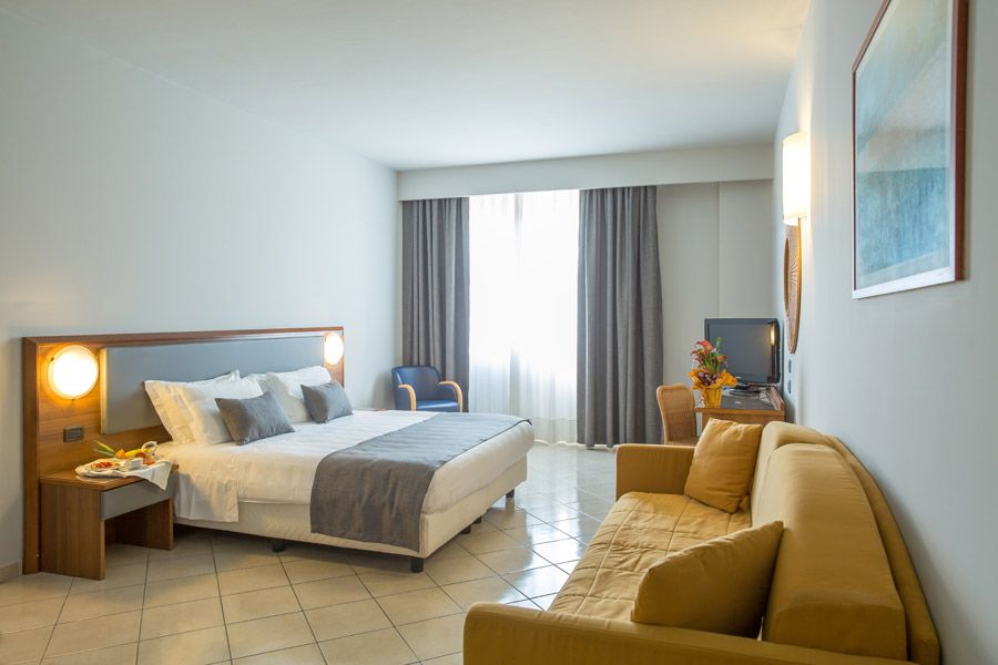 Deluxe room at Blu Hotel with double bed, sofa and window